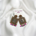 Antique Gold Toned Brass Jhumka Earrings With White Enamel Detail And Pink & Green Bead Drops